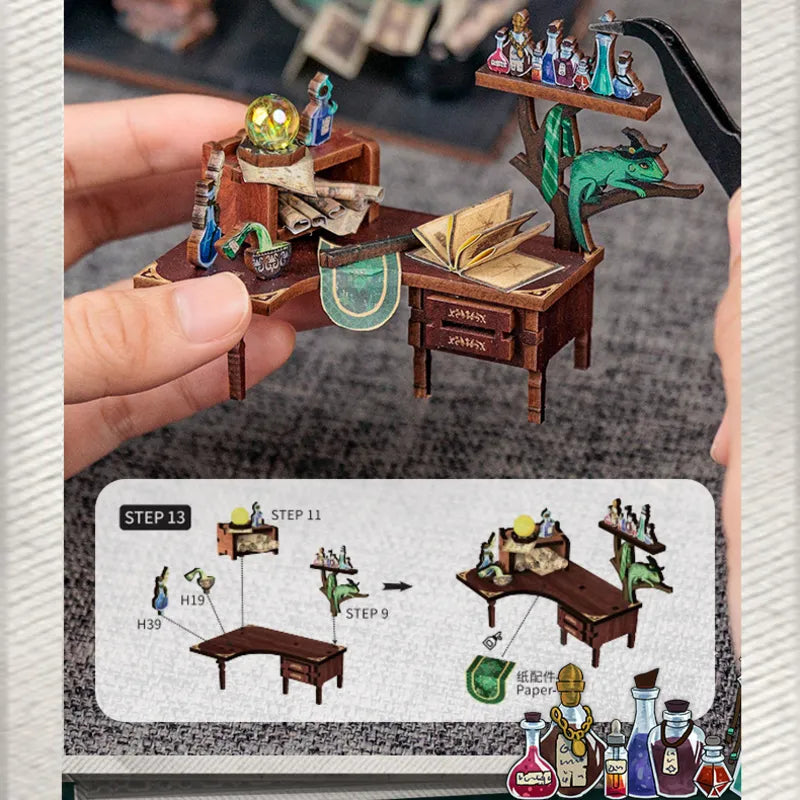 Montaggio della scrivania con libri, flaconi e creatura verde in miniatura