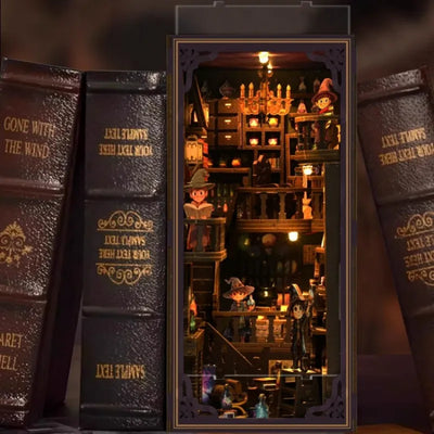 Book Nook Alchemy Master esposto tra libri con torre illuminata