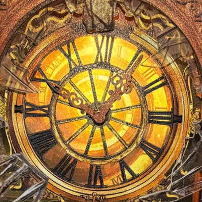 Primo piano del grande quadrante illuminato con numeri romani e lancette decorate