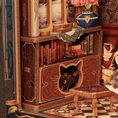 Dettagli dello studio felino con camino, ritratti, libri e gatto nero nascosto