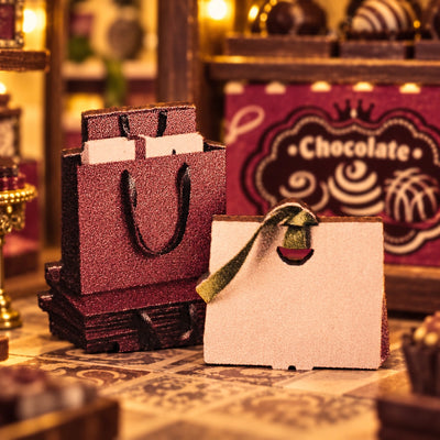 Miniatur-Geschenktüten vor der Schokoladenauslage