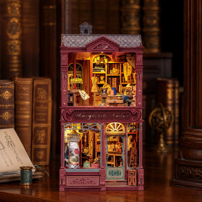 Book nook Marguerite Tailor inserito tra i libri di uno scaffale