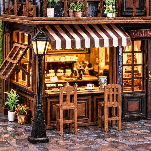 Zwei Stühle vor der Café-Theke unter einer Streifenmarkise