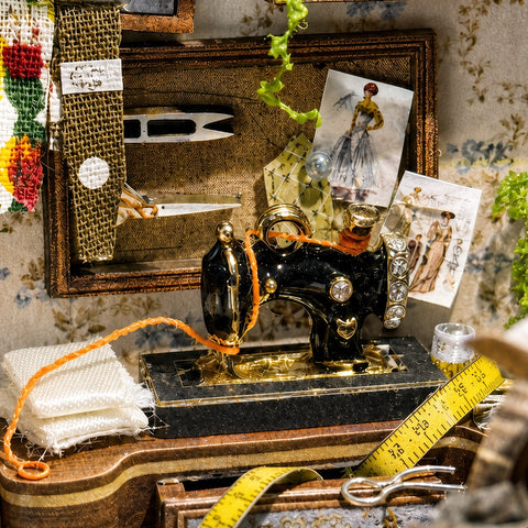 Historische Nähmaschine mit Maßband und Modezeichnungen im Atelier