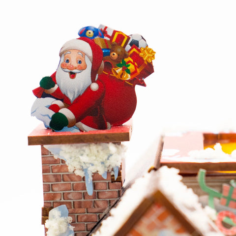 Weihnachtsmann mit Geschenkesack auf dem verschneiten Kamin