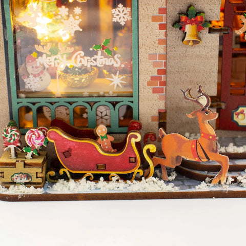 Rentier und roter Schlitten vor dem weihnachtlichen Schaufenster