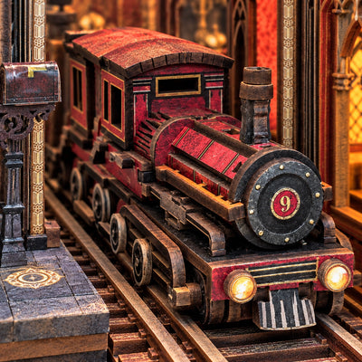 Rode miniatuurlocomotief op de rails onder de stationsboog