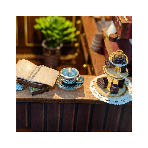Seitlicher Café-Tresen mit aufgeschlagenem Buch, Tasse und Gebäcketagere