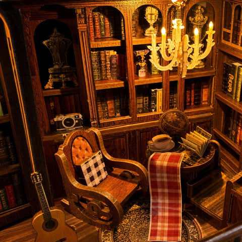 Lesesessel vor Bücherwand, Globus und warm leuchtendem Kronleuchter