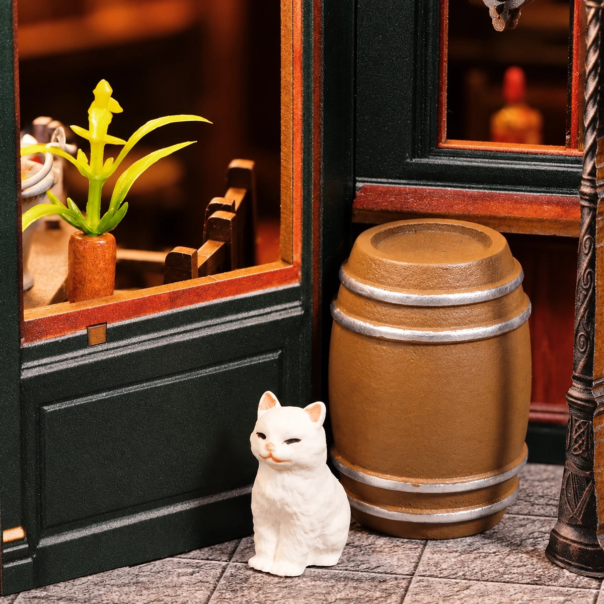 Weiße Katzenfigur neben einem Fass an der Pubfassade