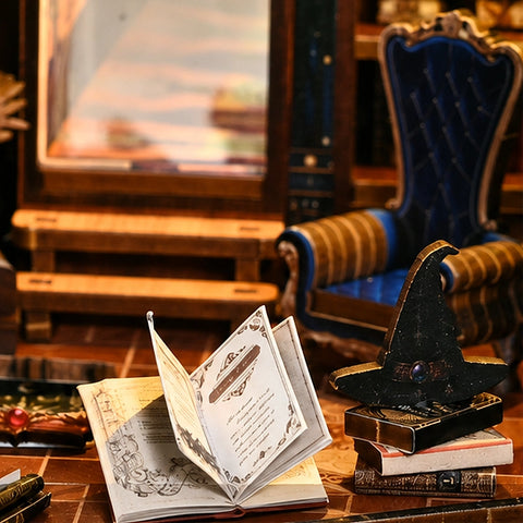 Miniatur-Schreibtisch mit offenem Zauberbuch, Bücherstapel und schwarzem Spitzhut