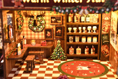 Flaschen- und Gläserregal neben kleinen Sitzplätzen und Weihnachtsbaum