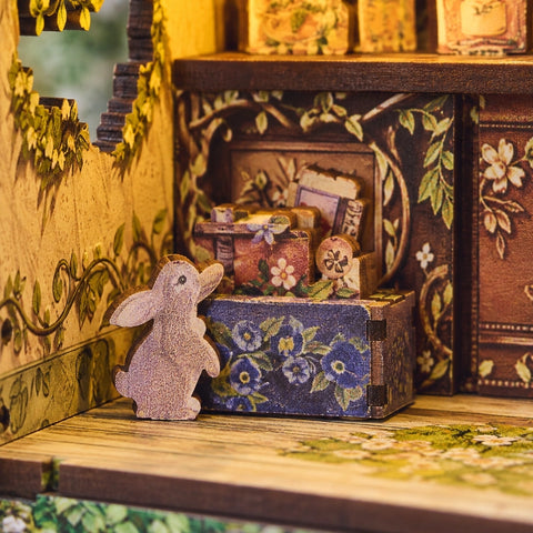 Kleine Hasenfigur neben floral verzierten Schachteln
